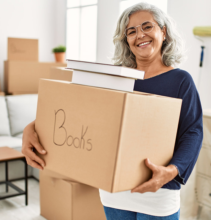 Smiling woman carrying boxes