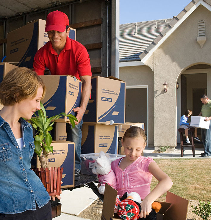 Unloading boxes from moving van with happy family image