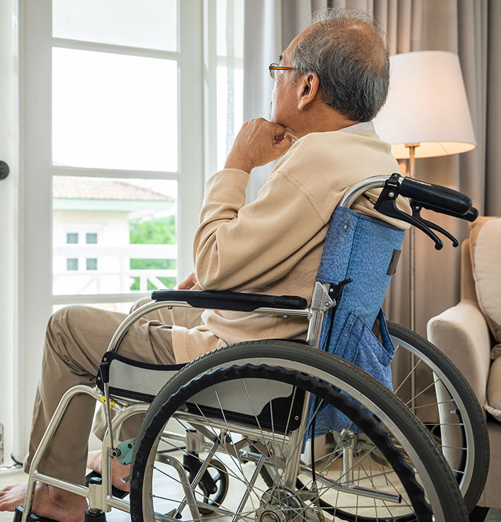 Senior in a wheelchair looking out a window image